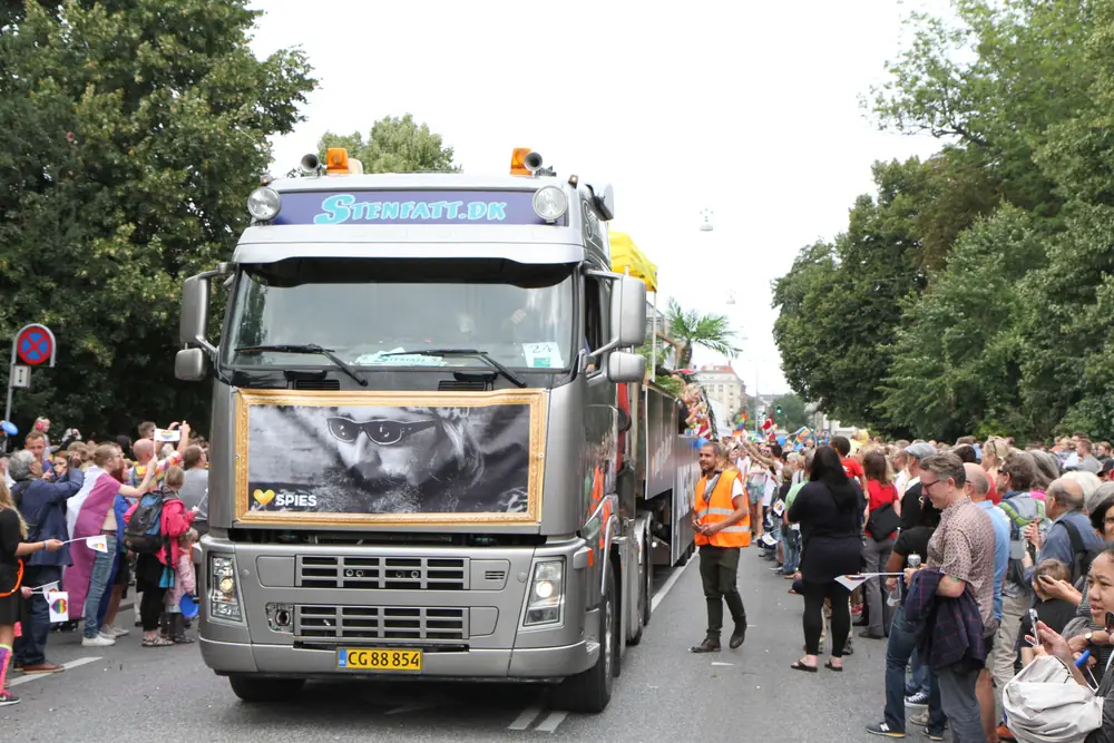 Grå lastbil med Stenfatt.dk på fronten, forrest i Copenhagen Pride-optoget med publikum på begge sider.